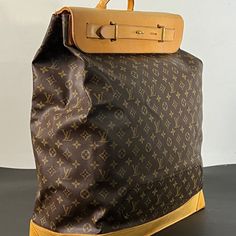 Large travel bag from the world-renowned Louis Vuitton. Crafted with meticulous attention to detail, this exquisite piece features the iconic Monogram canvas adorned with sumptuous tan cowhide leather accents, exuding sophistication and timeless elegance.  A testament to Louis Vuitton's legacy of exceptional design, this steamer bag sac showcases a near-perfect condition despite its age, reflecting the brand's commitment to quality craftsmanship. This large canvas and leather travel companion, n High-end Travel Backpack Shoulder Bag, Vintage Travel Bag In Signature Coated Canvas, Luxury Travel Bag With Leather Backing For Trips, Designer Travel Tote Backpack, Designer Travel Bags In Coated Canvas, Luxury Coated Canvas Backpack With Leather Handles, Luxury Backpack With Leather Handles And Coated Canvas, Elegant Coated Canvas Backpack For Travel, Vintage Business Bags In Signature Coated Canvas