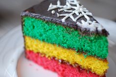 a slice of rainbow cake sitting on top of a white plate