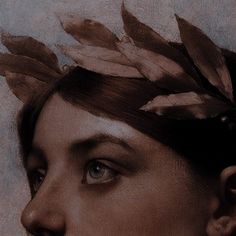 a woman with feathers on her head is looking off to the side, in sepia