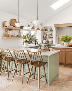 a kitchen filled with lots of counter top space and wooden chairs next to an island