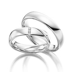 two white gold wedding rings with diamonds on each one and the word love is in the middle