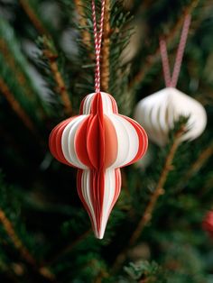 an ornament hanging from a christmas tree with red and white ornaments on it