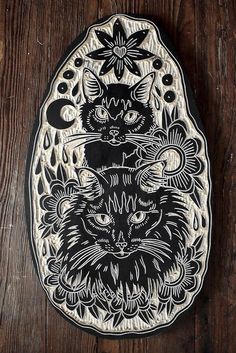 a black and white plate with a cat on it's face in front of a wooden background