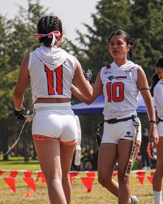 two female lacrosse players are talking to each other