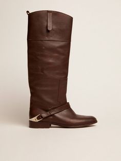 Horse-riding soul and vintage finish: our Charlie Boots encompass all the values that make us stand out, from a love of craftsmanship to maximum attention to detail. With this version, we have made a journey back to our origins to reinterpret one of our archive pieces. With a dark brown leather upper, these boots feature a clamp detail on the heel, to which is attached a tone-on-tone leather band on the instep. And the finely engraved Golden Goose signature on the back of the clamp adds the finishing touch. Golden Family, The Golden Goose, Exclusive Sneakers, Vintage Soul, Dark Brown Leather, Golden Goose, Mini Me, Horse Riding, Leather Band