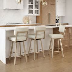 three stools sit in front of a kitchen island