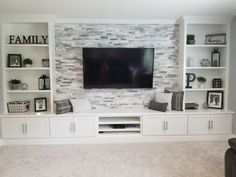 a living room with built in shelves and a flat screen tv mounted on the wall