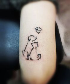 a dog with a paw and heart tattoo on its leg is sitting next to a woman's arm