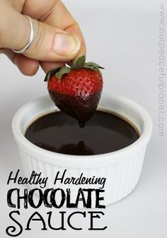 someone dipping a strawberry into chocolate sauce in a small white bowl with the words healthy hardening chocolate sauce