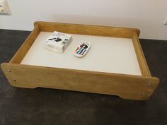 a remote control sitting on top of a wooden tray