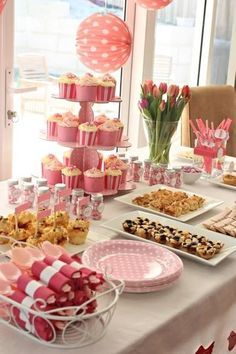 a table topped with lots of desserts and cupcakes