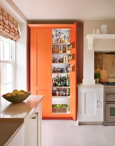 an orange pantry in the middle of a kitchen