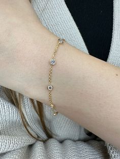 Bring a touch of elegance to your looks with this classic Diamonds by the Yard bracelet.  Featuring five round diamonds set in bezels on a delicate 14K gold Rolo chain, this piece is effortlessly chic. Material: 14K Yellow Gold Diamonds: Round Cut, Bezel Set *These are 100% naturally Earth-Mined Diamonds. Color: G Clarity: VS2 Length: 6.5Inches Elegant Diamond Bracelet With Bezel Setting, Dainty Round Diamond Bracelet With Diamond Cut, Delicate Gold Diamond Bracelet, Timeless 14k Gold Diamond Bracelet With Bezel Setting, Delicate Gold Diamond Bracelet With Bezel Setting, Gold Round Cut Dainty Diamond Bracelet, Gold Dainty Diamond Bracelet With Round Cut, Gold Dainty Round Cut Diamond Bracelet, Gold Dainty Diamond Bracelet