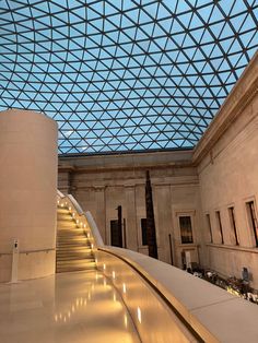 the inside of a large building with a glass ceiling and stairs leading up to it