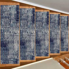 a room divider with blue rugs on the wall and wooden flooring in front of it