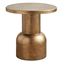 a round metal table with a gold finish on the top and an open end section