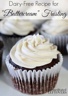 cupcakes with white frosting sitting on top of each other