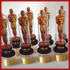 the oscars are lined up in their respective glass cases with gold and black bases