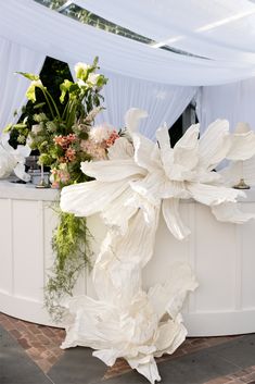 a large white flower arrangement sitting on top of a table