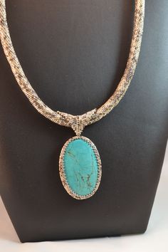 This original design focuses on a wonderful oval turquoise colored Howlite stone, and would be a great addition to any jewelry collection. This necklace will be perfect with a white shirt, turtleneck sweater, or business suit. A perfect gift for that special someone! Hand beaded in my Las Vegas studio, this piece includes a dyed Howlite oval pendant, along with Delica beads. The pendant is about 3 inches tall, 1 1/2 inches wide, and hangs from a beaded rope that is about 19 inches long. For more Turquoise Oval Stone Necklaces, Oval Turquoise Necklaces With Stones, Turquoise Oval Stone Necklace, Oval Turquoise Stone Necklace, Oval Cabochon Turquoise For Jewelry Making, Handmade Turquoise Necklace With Oval Pendant, Oval Turquoise Necklace With Natural Stones, Elegant Oval Turquoise Necklace With Large Pendant, Luxury Turquoise Oval Necklace