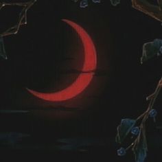 a red moon is seen through the branches of a tree in front of a dark background