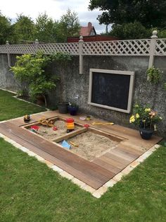 an outdoor play area with sand in the middle and toys on the ground next to it