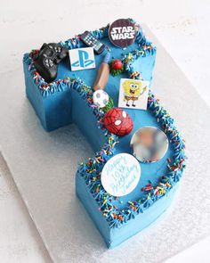 a birthday cake that is shaped like the letter e with various items on it and sprinkles