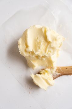 a spoon full of ice cream sitting on top of a white paper bag next to a wooden spatula