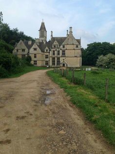 an old house with a dirt road leading to it