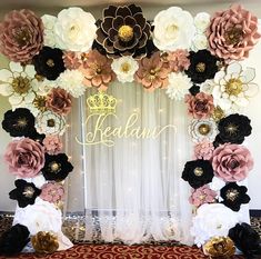 the backdrop is made up of paper flowers and black, white, pink and gold