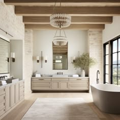 a large bathroom with two sinks, tub and chandelier hanging from the ceiling