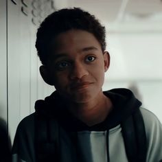 a young boy wearing a hoodie looking at the camera with an intense look on his face