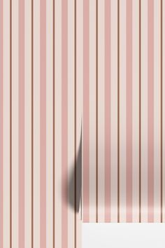 an empty piece of paper is placed in front of a striped wall