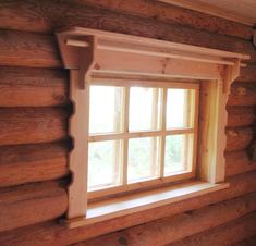 a window in a log cabin with wood trim