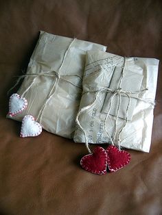 two small hearts are tied up next to an envelope