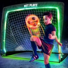 a young man kicking a soccer ball in front of a neon net playz sign