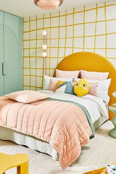 a bedroom decorated in pastel colors with yellow accents