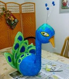 a stuffed peacock sitting on top of a table