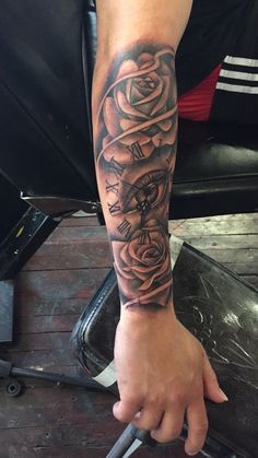 a person with a clock and roses tattoo on their arm