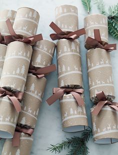 four wrapped presents with brown bows and trees on them are sitting on a marble surface