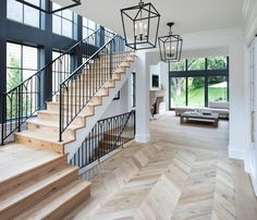 a large open floor plan with wood floors and stairs leading up to the second story