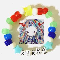 a colorful bracelet with an image of kikoo on it and the word kikoo spelled in small letters