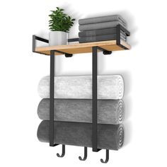 a shelf with towels and a potted plant on it next to a wall mounted towel rack