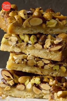 three pieces of almond bars stacked on top of each other with nuts in the middle