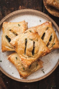 four pastries on a plate with herbs