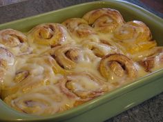 a green casserole dish filled with cinnamon rolls