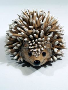 a close up of a toy hedgehog on a white surface with lots of spikes