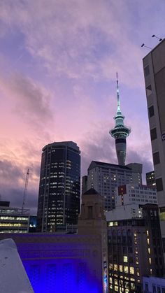 the city skyline is lit up at night with blue lights and tall buildings in the background