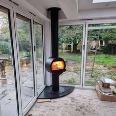 a fire place in the middle of a room with large glass doors on both sides