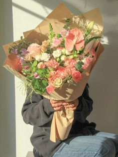 a person sitting down holding a bouquet of flowers